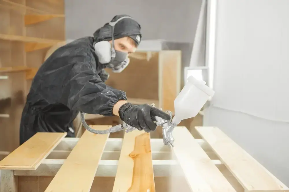 Thợ kỹ thuật đang phun bản vệ mặt gỗ